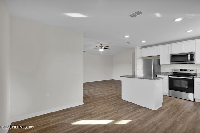 kitchen featuring appliances with stainless steel finishes, white cabinets, a center island, ceiling fan, and dark wood-type flooring