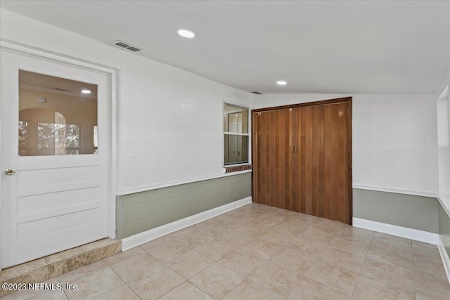 tiled spare room with lofted ceiling