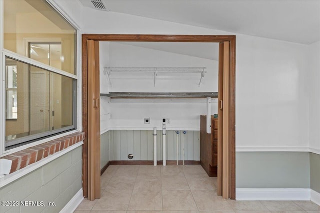 clothes washing area with light tile patterned floors