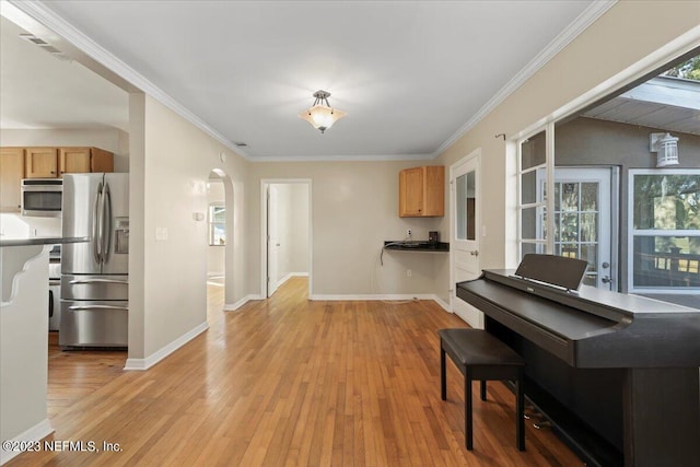 182 Cargo Way, Keystone Heights, FL 32656 - kitchen featuring stainless steel appliances, arched walkways, light wood-style floors, baseboards, and crown molding