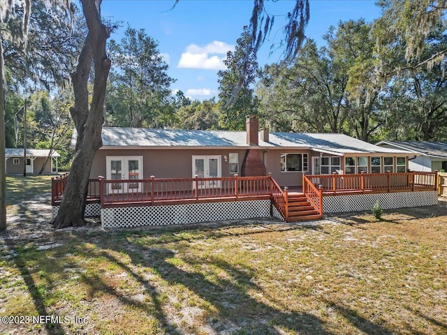 182 Cargo Way, Keystone Heights, FL 32656 - back of property with french doors, a deck, a lawn, metal roof, and a chimney