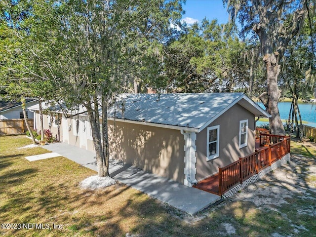 view of front of home featuring a deck with water view and a front yard