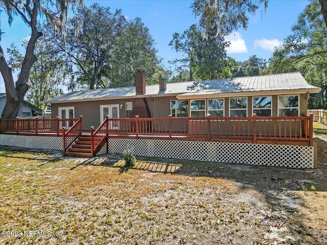 182 Cargo Way, Keystone Heights, FL 32656 - back of property featuring french doors, a chimney, a wooden deck, and metal roof