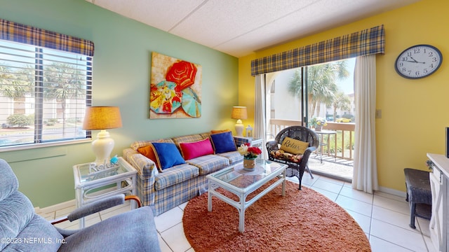 living room featuring a healthy amount of sunlight, a textured ceiling, baseboards, and light tile patterned floors