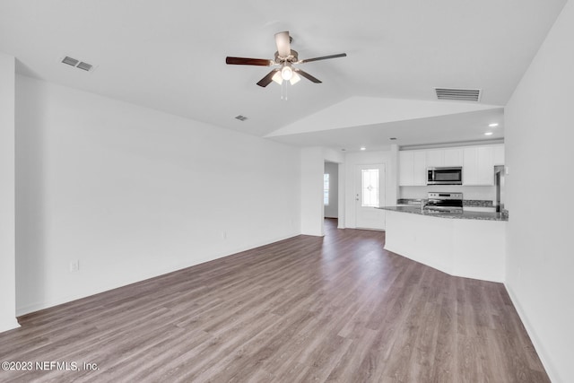 unfurnished living room with vaulted ceiling, ceiling fan, wood finished floors, and visible vents