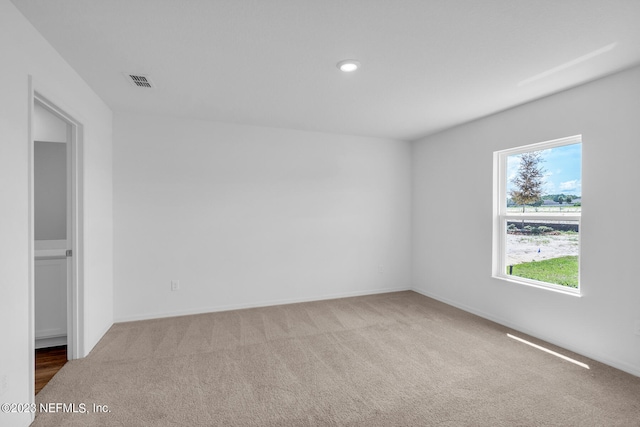 empty room featuring carpet floors and visible vents