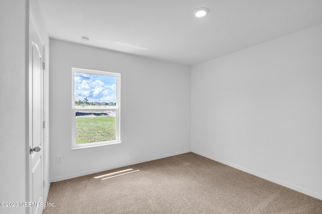 unfurnished room featuring carpet and baseboards