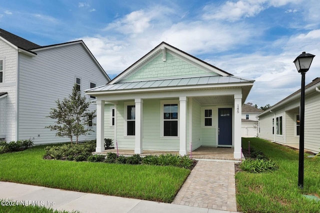 bungalow-style home with a front yard and covered porch