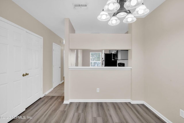 unfurnished dining area with a chandelier and hardwood / wood-style flooring