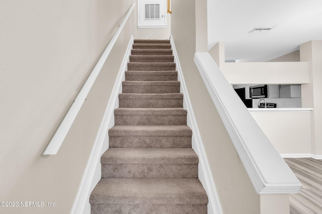 stairs featuring hardwood / wood-style floors