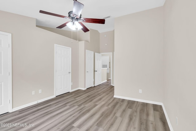 unfurnished bedroom featuring ceiling fan, light hardwood / wood-style flooring, and vaulted ceiling