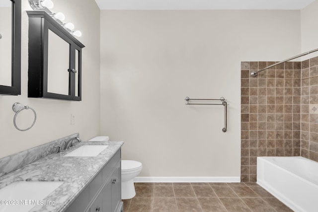 full bathroom featuring tile patterned flooring, vanity, toilet, and tiled shower / bath