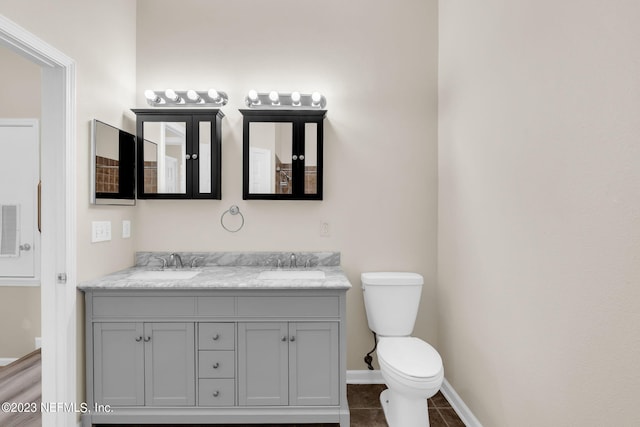 bathroom featuring tile patterned floors, vanity, and toilet