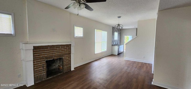 unfurnished living room with a textured ceiling, dark wood-type flooring, a fireplace, sink, and ceiling fan