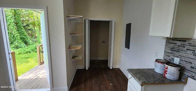 hall with dark wood-type flooring and electric panel