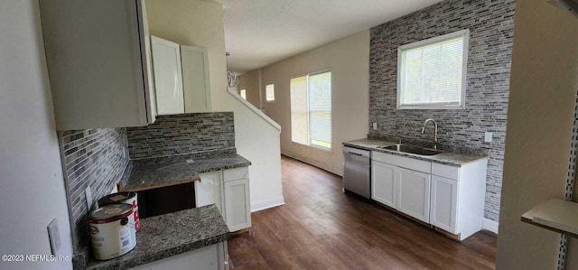 kitchen featuring dishwasher, sink, white cabinets, dark wood-type flooring, and decorative backsplash