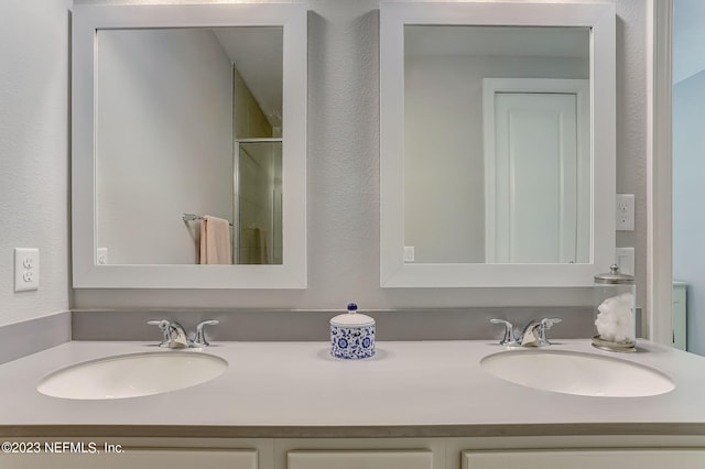 bathroom with vanity and a shower with door