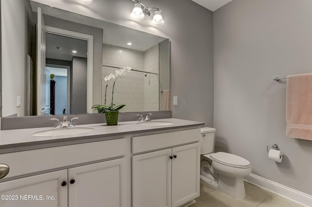 bathroom with tile patterned flooring, vanity, toilet, and walk in shower