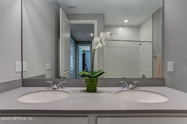 bathroom with vanity and a tile shower