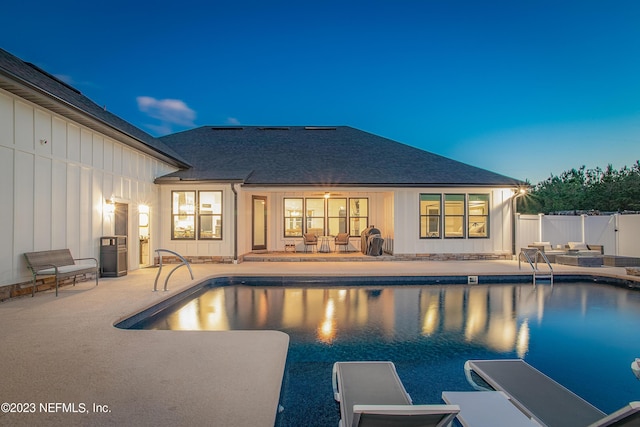 pool at dusk featuring a patio area