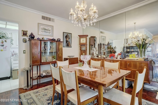 dining room with dark parquet floors, ornamental molding, and a chandelier