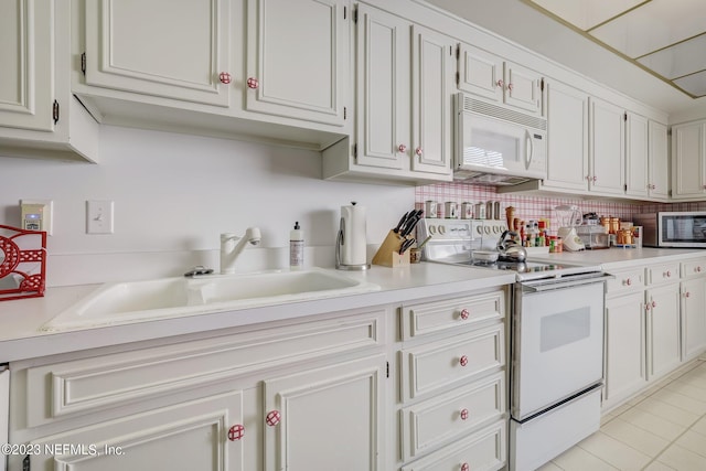 kitchen featuring white cabinets, white appliances, sink, and light tile patterned floors