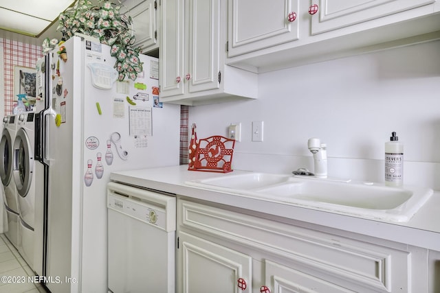 kitchen with white dishwasher, white cabinets, sink, independent washer and dryer, and light tile patterned floors