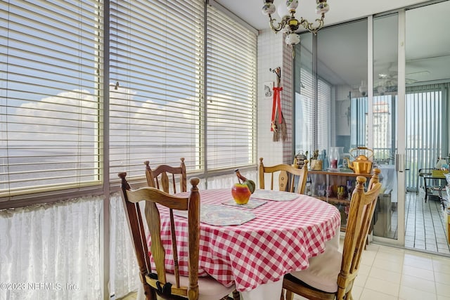 dining area featuring plenty of natural light, light tile patterned floors, and an inviting chandelier