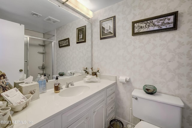 bathroom with vanity, toilet, and a shower with shower door