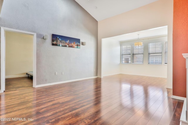 unfurnished living room featuring hardwood / wood-style flooring and lofted ceiling