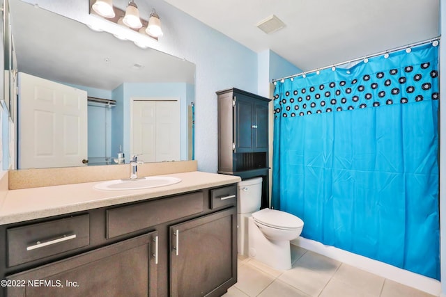 bathroom featuring vanity, walk in shower, tile patterned floors, and toilet