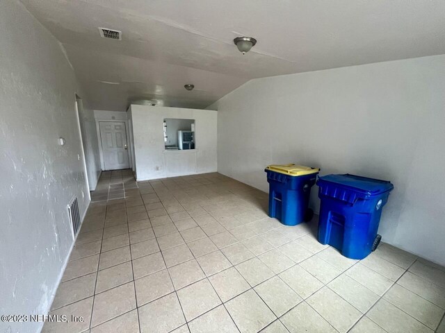 interior space with vaulted ceiling and light tile patterned flooring