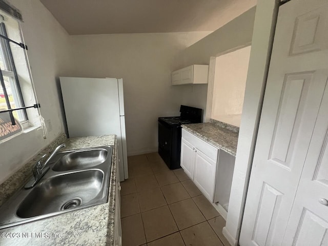 kitchen featuring tile patterned flooring, a sink, white cabinets, and black electric range