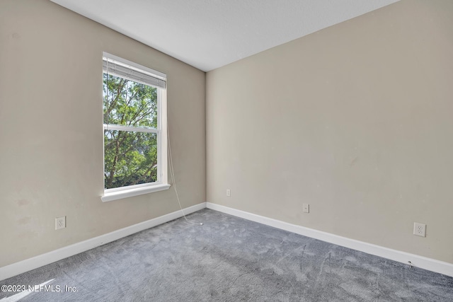 spare room with carpet and baseboards