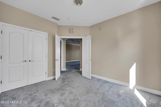 unfurnished bedroom with a closet and carpet flooring