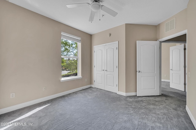 unfurnished bedroom featuring a closet, ceiling fan, and dark carpet