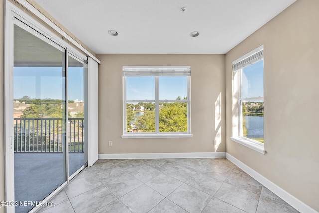 tiled spare room with a water view