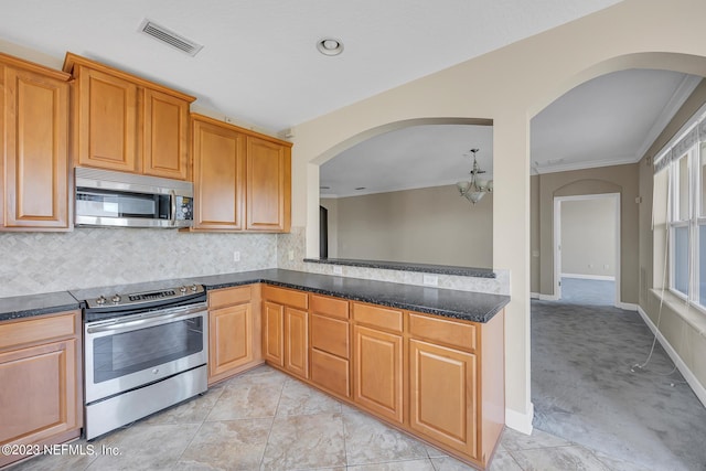 kitchen with dark stone countertops, light tile floors, backsplash, and appliances with stainless steel finishes