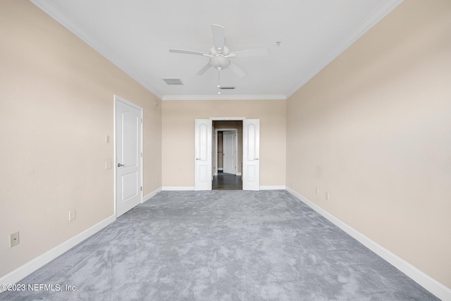 spare room featuring dark colored carpet, ceiling fan, and crown molding