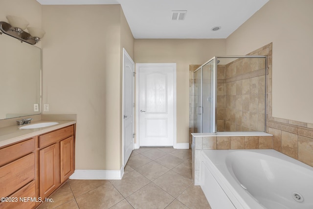 bathroom with tile floors, shower with separate bathtub, and vanity with extensive cabinet space