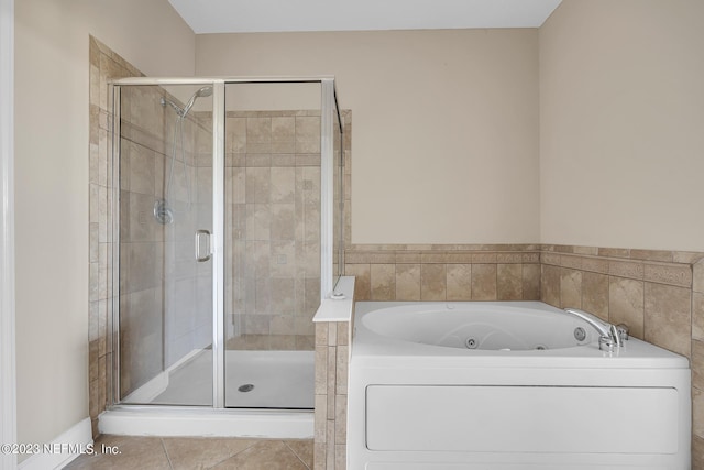 bathroom featuring tile floors, shower with separate bathtub, and washer / dryer