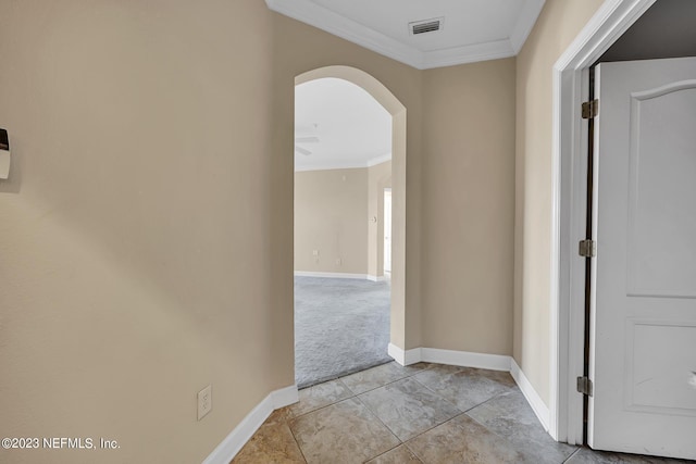 hallway featuring crown molding and light tile floors