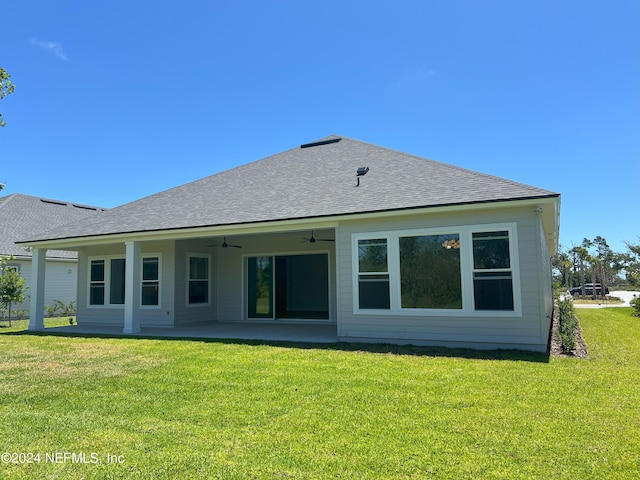 rear view of property featuring ceiling fan, a patio area, and a lawn