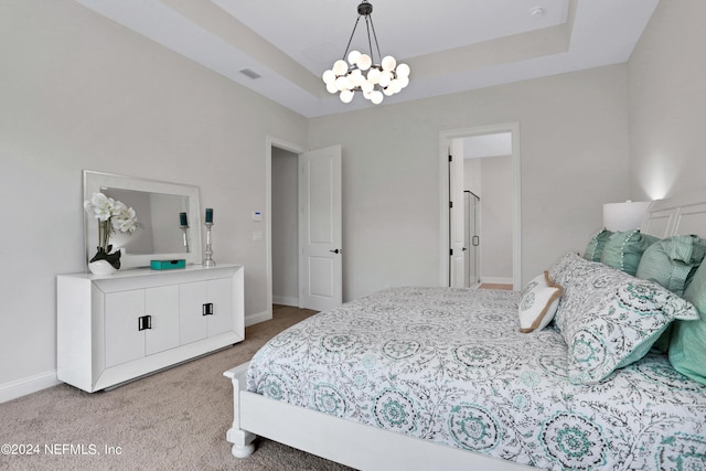 bedroom featuring a tray ceiling, light colored carpet, visible vents, and baseboards