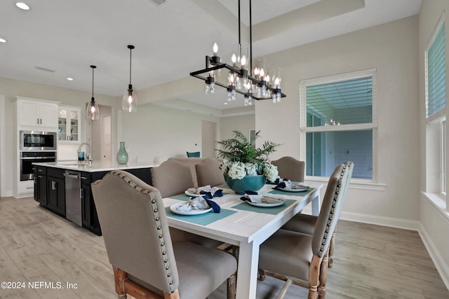 dining room with light wood finished floors, recessed lighting, and baseboards