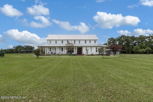 farmhouse inspired home featuring metal roof and a front lawn