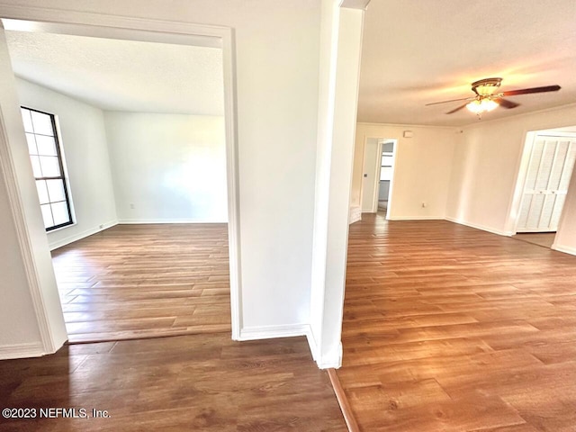 hallway with hardwood / wood-style floors and a textured ceiling