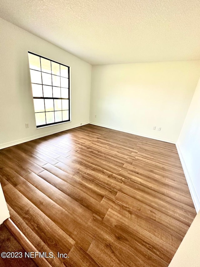 spare room with hardwood / wood-style floors and a textured ceiling