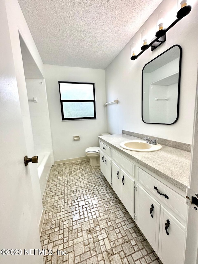 full bathroom with vanity, shower / bathing tub combination, a textured ceiling, and toilet