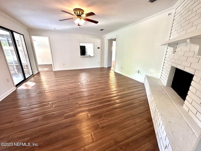 unfurnished living room with ceiling fan, a brick fireplace, ornamental molding, and dark hardwood / wood-style flooring